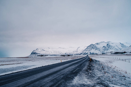 以雪山为背景 以冰冻道路为前景的暴风雪期间冰岛公路冬季景观照片 正版商用图片0nhlpp 摄图新视界