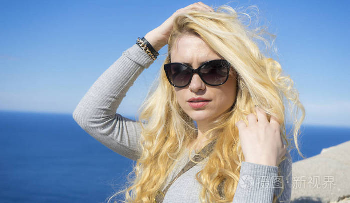 阳光明媚的夏季假期年轻金发碧眼的长发和快乐的太阳镜靠近地中海