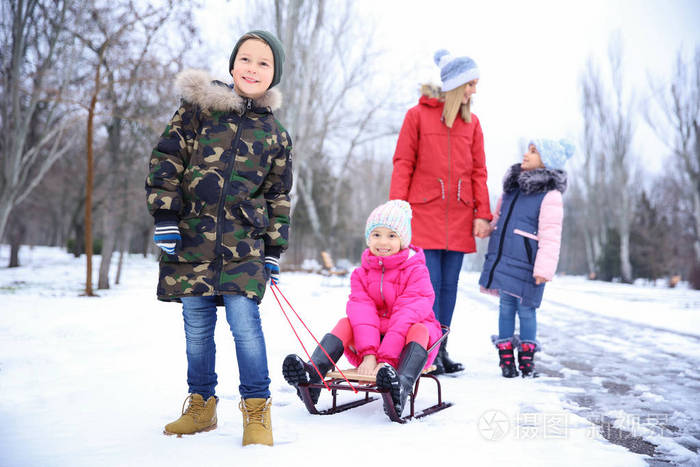 愉快的母亲与孩子在雪公园在冬天假期