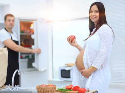 快乐怀孕夫妇的素食主义者在厨房