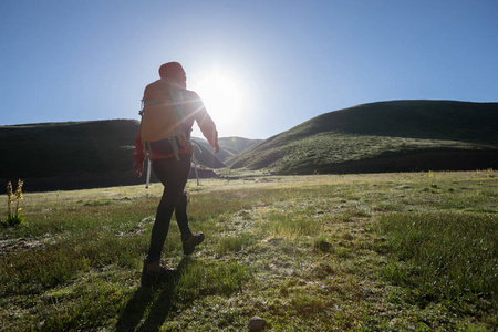徒步旅行的背包妇女远足在日出山