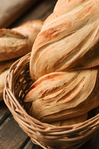 美味的新鲜烤面包在柳条篮子在木桌上