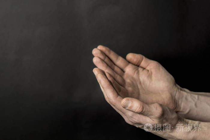 在黑色背景下祈祷穆斯林的手