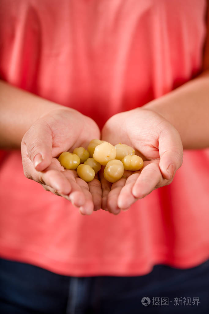 紧紧抓住女人双手捧着一颗星醋栗的果实acidus被称为otaheite醋栗星g