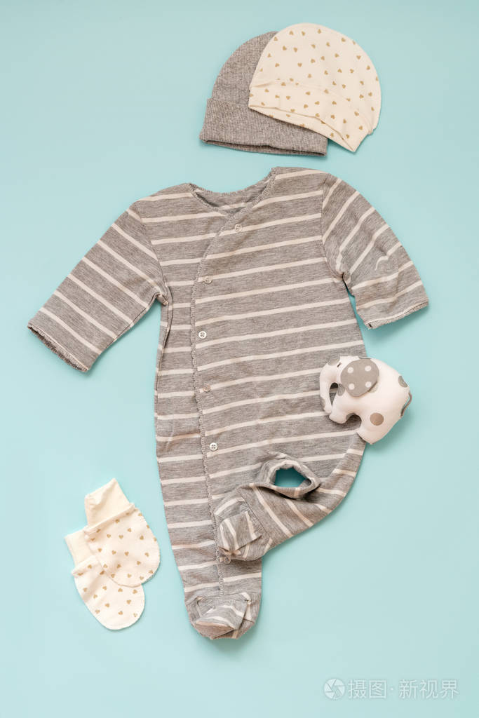 在蓝色背景下为女孩或男孩准备的婴儿衣服: 一具长袖条纹的身体, 精选