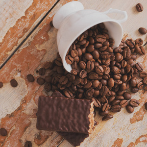 杯咖啡与谷物散落在一个木质的背景。巧克力饼干, 甜甜点