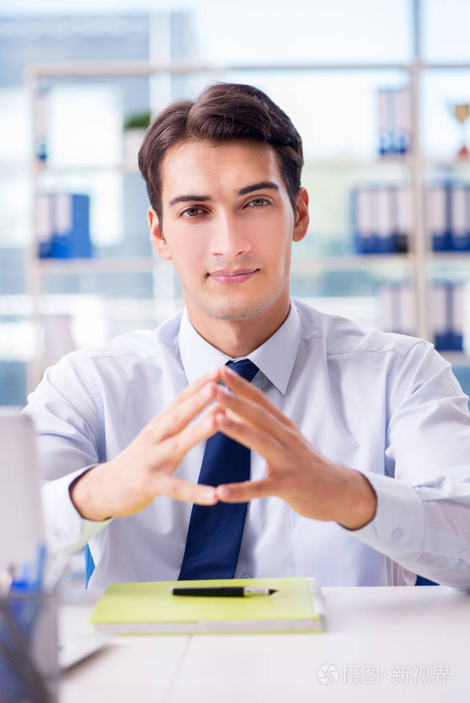 年轻英俊的生意人员工在办公室工作在办公桌上