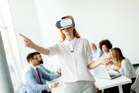 在办公室开会时使用虚拟现实模拟器的年轻女子