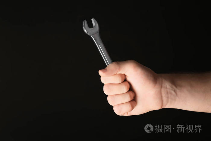 黑色背景扳手的男性汽车技工手
