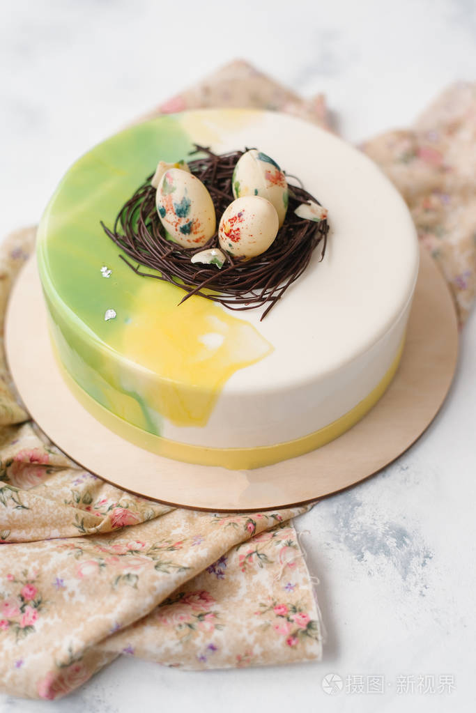 大理石面上的木盘子和米色餐巾上放有鸡蛋的琉璃蛋糕