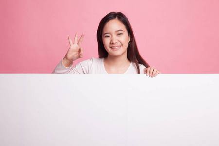 年轻的亚洲女人与空白符号显示 Ok