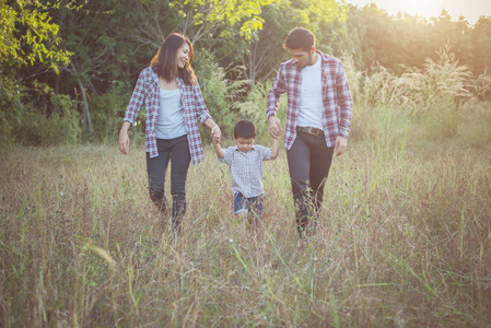 快乐的年轻家庭花时间一起在外面绿色 natur