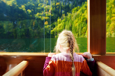 小女孩享受 Konigssee 的深绿色水域的看法, 而乘坐电动船