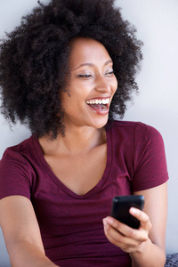 特写年轻黑人女子用手机笑的肖像