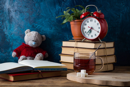 打开日记, 一杯热茶, 一本书, 一个暗蓝色的红色闹钟