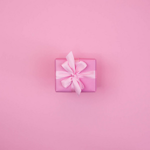 装饰节日礼品盒粉红色的背景粉色的颜色。平面平顶视图