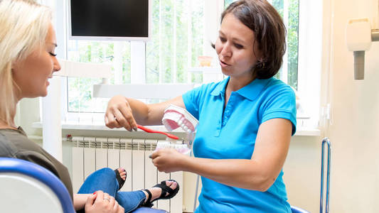 女牙医肖像与病人谈牙齿卫生