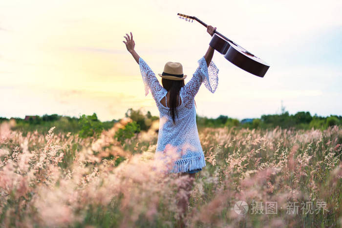 妇女高兴与吉他在草甸。旅游和日落, 软, 选择焦点。生活方式与幸福观