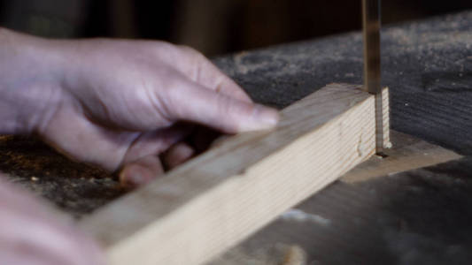 木匠细节削减一块木材与带锯
