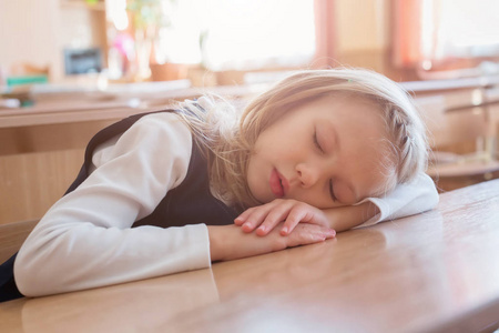 在学校睡觉的女孩在课桌旁睡觉.学生.学生学习照片