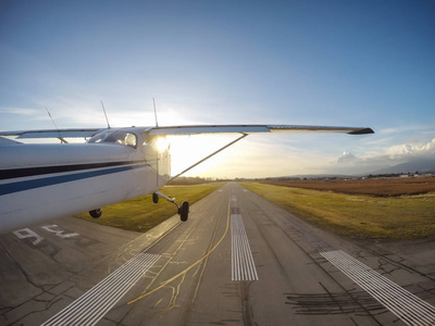 一架小型飞机在充满活力的日落时起飞跑道.
