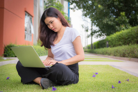 女实业家在户外花园里使用笔记本电脑在家工作