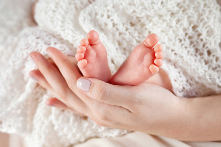 宝宝脚在母亲的手中。妈妈和她的孩子