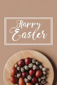复活节彩蛋的最高视图在木盘子与快乐的复活节题字