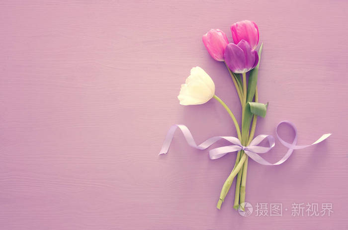 粉红色和白色的郁金香花束在柔和的木质背景.顶部视图