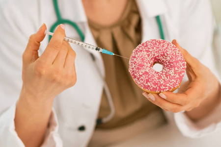 制作成甜甜圈使用糖尿病注射器注射的医生身上的特写