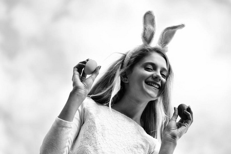 快乐的复活节兔子的耳朵，女孩鸡蛋在蓝蓝的天空上