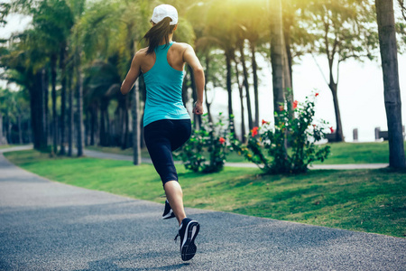 运动健身妇女在热带公园奔跑