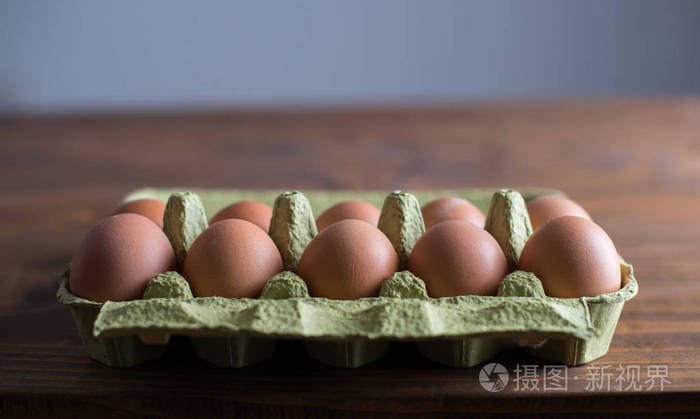 一盒在木桌上打的新鲜鸡蛋