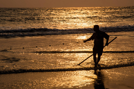 在日落时利用渔网捕鱼钓鱼的剪影