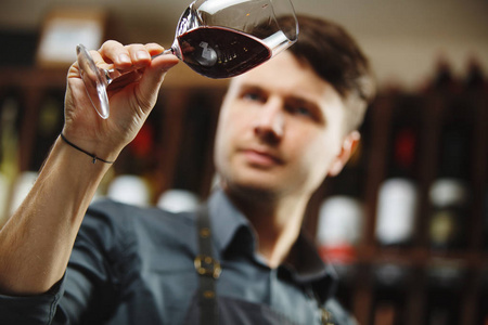 经验丰富的品酒师品尝葡萄酒.酒吧招待在除气时品尝红酒.