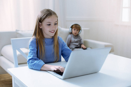 微笑的女孩看着笔记本电脑的屏幕