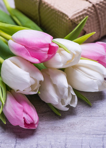春天的郁金香花粉红色, 白色, 红色, 礼物, 在老式灰色桌上的礼物盒。妇女或母亲节问候