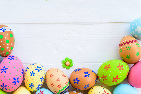 复活节快乐五颜六色的复活节彩蛋与彩色纸花白色木质背景