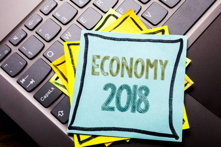 概念手写文字标题启示显示经济2018。Word 财务的商业概念未来的计划写在便笺纸上的深色键盘背景上