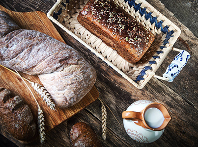 构成黑面包的板, 老式刀, 牛奶, 小麦片, 坚果在桌子上和旧的背景, 健康饮食的概念, 设置。种子