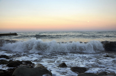 海面上的日出与波浪和石头