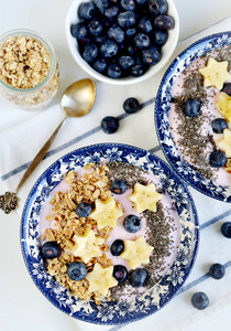 新鲜早餐酸奶与麦片香蕉莓果嘉种子燕麦白色背景健康生活方式