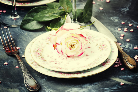 节日餐桌设置情人节, 盘子和粉红色香槟情侣眼镜, 灰色背景, 选择性焦点