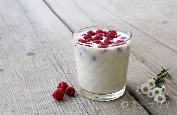一杯树莓和牛奶, 装饰在木桌背景上的花朵