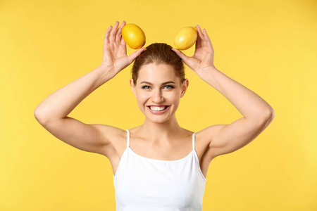 有趣的年轻妇女与成熟的柠檬在颜色背景