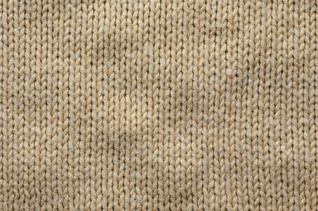 有规律图案的米色羊毛针织面料的织构。针织毛衣空白背景