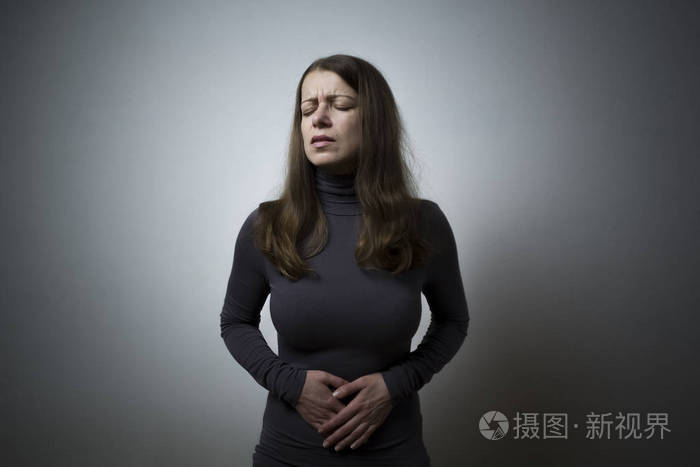 腹泻.一个女人抱着她的胃