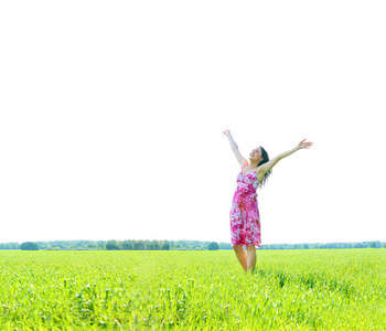 年轻快乐的女人在绿地里举手。绿草田