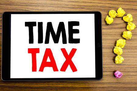 写入显示时间税的文本。税务金融的商业概念在平板电脑上写上用折叠纸做问号的木制背景的提示