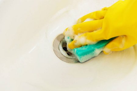 用黄色橡胶手套清洗浴室洗涤槽用蓝色海绵家务, 春天清洁概念
